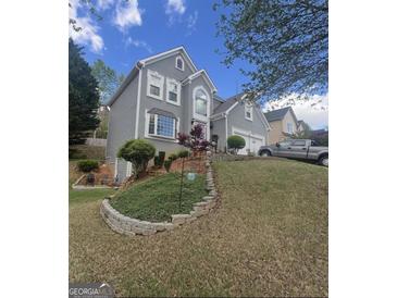 Charming two-story home with landscaped yard, stone accents, and a two-car garage on a sunny, clear day at 750 Gates Ln, Alpharetta, GA 30022