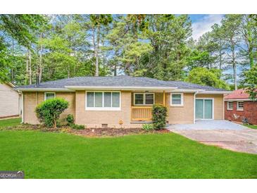 Charming single-story brick home featuring a well-manicured lawn and a cozy front porch at 1089 Canal St, Decatur, GA 30032