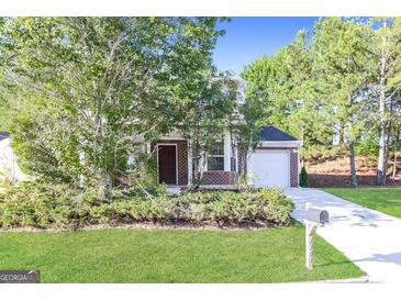 Charming home featuring a brick facade, manicured lawn, and attached garage at 7161 Bowie Dr, Lithonia, GA 30038