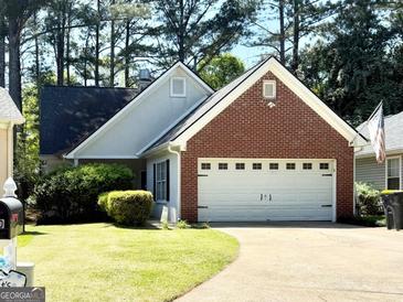 Charming one-story home featuring a well-manicured lawn and a two-car garage with a brick facade at 110 S Fairfield Dr, Peachtree City, GA 30269