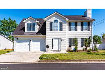 Charming two-story home features a two-car garage and a well-maintained front yard at 2554 Willenhall Way, Lithonia, GA 30058