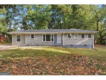Charming single-story home with a gray brick facade and a well-maintained front yard at 3456 Glensford Dr, Decatur, GA 30032