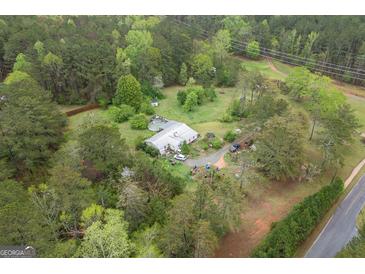 A captivating aerial view of a secluded home nestled among lush greenery with a winding driveway and a private pool at 24 Shiloh Church Rd, Carrollton, GA 30116