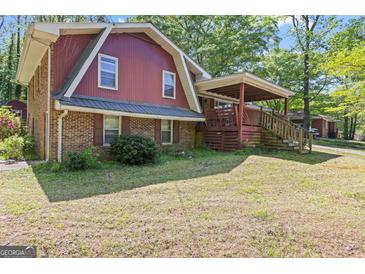 Charming home featuring a brick foundation, red siding, and a covered porch for outdoor enjoyment at 9155 Lakeview Sw Dr, Covington, GA 30014