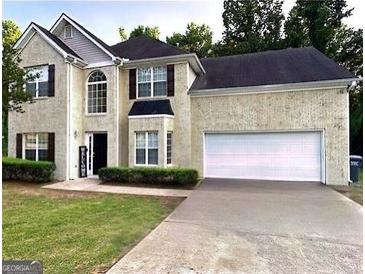 Charming two-story home featuring a well-manicured lawn and attached two car garage at 220 Camerons Way, Covington, GA 30016
