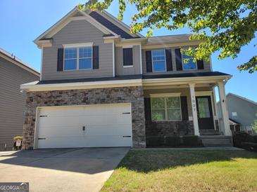 Charming two-story home boasts stone accents, gray siding, and a well-maintained front lawn at 1007 Oglethorpe Ct, Woodstock, GA 30188