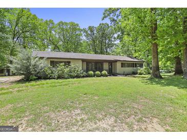 Charming single-story home with a well-maintained lawn and mature trees, offering a serene and inviting curb appeal at 482 E Lake Rd, Mcdonough, GA 30252