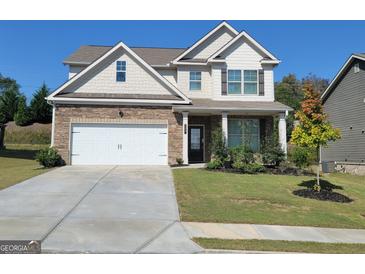 Charming two-story home featuring a stone facade, manicured lawn, and a two-car garage at 502 Hinton Farm Way, Dacula, GA 30019