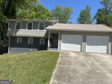 Split-level home with attached two-car garage and a concrete driveway at 9503 Winding Way Ln, Jonesboro, GA 30238