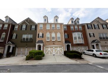 Charming multi-colored townhomes, featuring a beige townhome in the center, each with a front-entry garage and manicured landscaping at 6089 Indian Wood Se Cir, Mableton, GA 30126