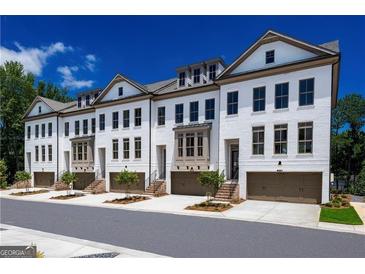 Charming townhomes featuring a light exterior, garage, and manicured landscaping at 3028 Pruitt Ln, Smyrna, GA 30080