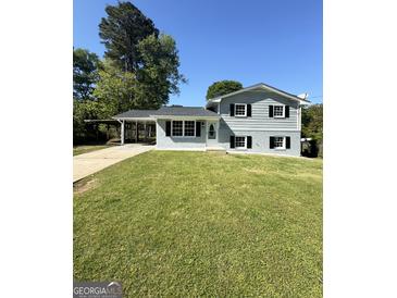 Charming two-story home featuring a well-manicured lawn and a convenient carport at 6505 Allatoona Rd, Morrow, GA 30260