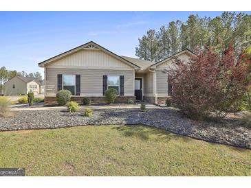 Charming single-story home with well-maintained lawn, landscaping, and neutral siding and trim at 130 S Meadows Ridge Dr, Grantville, GA 30220