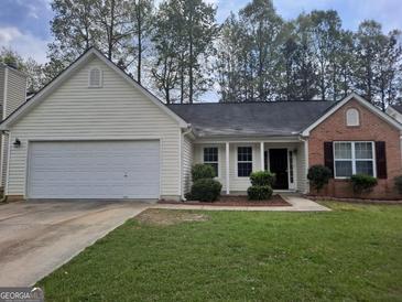 Charming single-Gathering home featuring mixed brick and vinyl siding, a two-car garage, and a well-maintained lawn at 114 Revere Turn, Fairburn, GA 30213