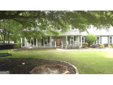 Charming two-story home featuring a covered front porch with a star and swing at 3650 Bay Leaf Dr, Loganville, GA 30052