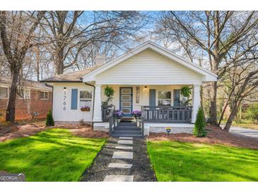 Charming bungalow with blue-trimmed windows, stone pathway, and well-manicured lawn at 1766 Ware Ave, East Point, GA 30344