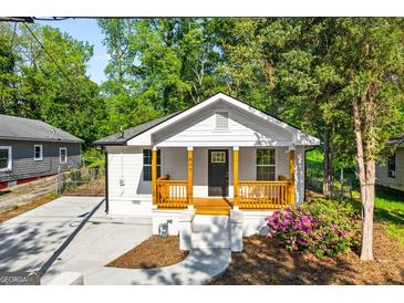 Charming renovated home featuring a cozy front porch with wood railing and well-manicured landscaping at 849 Wood Nw St, Atlanta, GA 30318