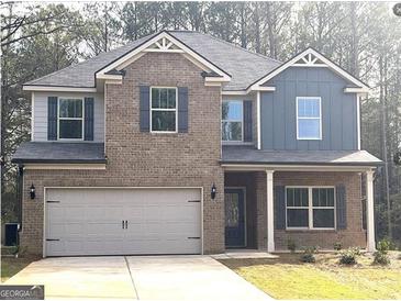 Charming two-story home with brick facade, well-manicured lawn, and attached two-car garage at 305 Wheeler Creek Ln # 21, Mcdonough, GA 30252