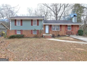 Charming split-level home features a mix of brick and siding, plus vibrant red shutters at 77 Crystal River Dr, Riverdale, GA 30274