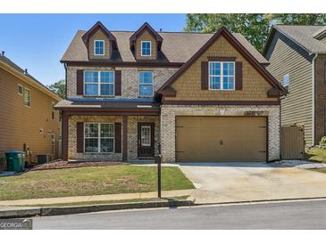 Charming two-story home features brick facade, dormer windows, and a two-car garage at 2638 Lake Manor Cir, Duluth, GA 30096