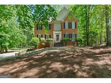 Charming two-story brick home with black shutters, lush landscaping, and a welcoming front entrance at 9276 Fieldstone Ct, Jonesboro, GA 30236