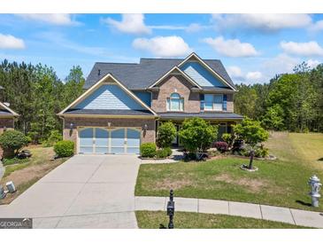 Charming two-story home boasts a brick facade, blue accents, and a well-manicured front yard at 1154 Ridge Hollow Ln, Lawrenceville, GA 30043