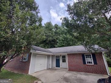 Charming single-story home featuring a brick facade, well-maintained lawn, and attached garage at 2039 Faith Cv, College Park, GA 30349