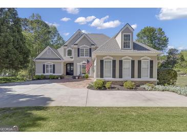 Stunning two-story stucco home with manicured lawn and a large circular driveway, showing impeccable curb appeal at 1105 Astoria Ln, Peachtree City, GA 30269