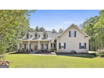 Charming two-story home with a welcoming front porch, manicured lawn, and beautiful landscaping with mature trees at 49 Moss Cts, Palmetto, GA 30268