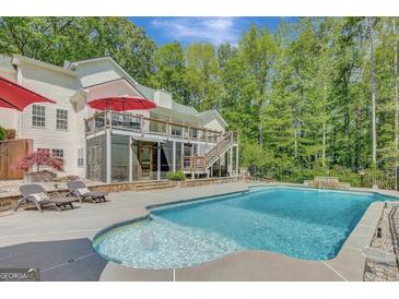 Inviting backyard pool with waterfall feature, surrounded by lounge chairs and lush greenery at 140 Horton Creek Trl, Brooks, GA 30205