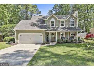 Charming two-story home with a well-manicured lawn, two-car garage, and inviting front porch at 308 Summer Pl, Peachtree City, GA 30269
