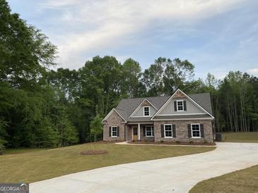 Charming brick home featuring a well-manicured lawn and a long concrete driveway at 2117 Ella Springs Dr, Covington, GA 30014