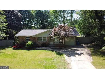 Charming single story brick home featuring a well-manicured lawn and a mature tree in the front yard at 2836 Belaire Cir, Doraville, GA 30340