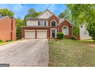 Two-story brick home featuring an attached two-car garage and a manicured front lawn at 122 Ardenlee Dr, Peachtree City, GA 30269