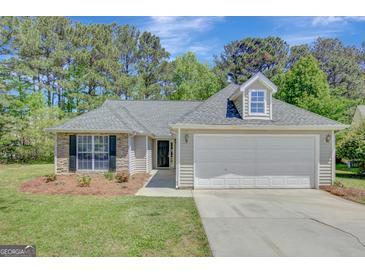Charming single-story home featuring a well-maintained lawn, a two-car garage, and beautiful stone accents at 8032 Highland Pkwy, Fairburn, GA 30213