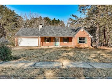 Charming brick home featuring a well-maintained lawn, attached garage, and covered front porch at 113 Elmwood Dr, Hampton, GA 30228
