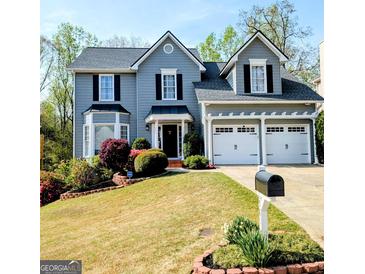 Charming two-story home with a manicured lawn, two-car garage, and attractive landscaping at 1581 Shetland Pony Nw Ct, Suwanee, GA 30024
