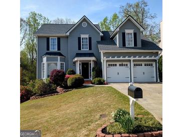 Charming two-story home with manicured lawn, lush landscaping, and a two-car garage at 1581 Shetland Pony Nw Ct, Suwanee, GA 30024
