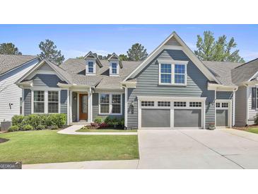 Charming blue two-story home with a well-manicured lawn and a two-car garage at 608 White Cedar Ct, Peachtree City, GA 30269