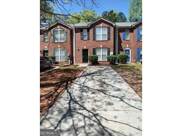 Attractive brick townhomes with well-maintained landscaping and a long driveway at 349 Saratoga Pl, Riverdale, GA 30296