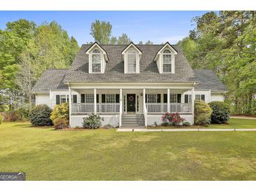 Charming home with a welcoming front porch, dormer windows and a well-manicured lawn at 225 Mapledale Trl, Sharpsburg, GA 30277