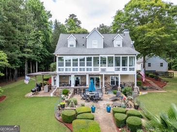 Expansive backyard with patio, outdoor kitchen, lush landscaping, and screened in porch great for entertaining and relaxing at 270 Polk Rd, Covington, GA 30014