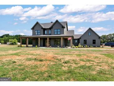 Charming two-story farmhouse with a welcoming front porch and large front yard at 4711 H D Atha Rd, Covington, GA 30014