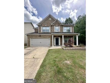 Charming two-story brick home featuring a two-car garage and a well-manicured front lawn at 1253 Heartwood Ave, Mcdonough, GA 30253