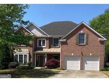 Charming two-story brick home featuring a two-car garage and beautifully landscaped front yard at 514 Augusta Dr, Canton, GA 30115