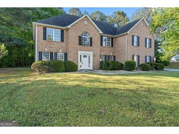 Charming brick two-story home with black shutters, white door, and well-manicured lawn at 643 Rangeley Meadows Ct, Hampton, GA 30228