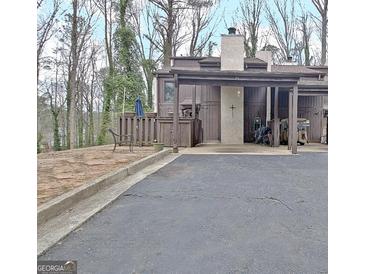 View of the home's exterior and driveway, with a carport, and landscaping at 26 Cobblestone Crk, Peachtree City, GA 30269
