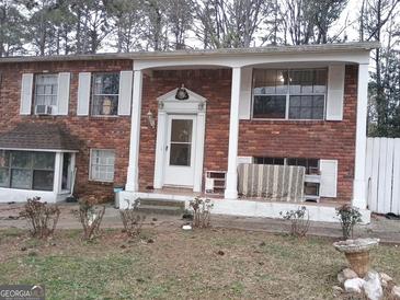 Traditional brick home featuring a covered front porch and shuttered windows at 1025 Lynwood Pl, Forest Park, GA 30297