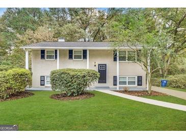 Charming two-story home features a white brick exterior, dark shutters, and a well-manicured lawn at 3798 Bakers Ferry Sw Rd, Atlanta, GA 30331