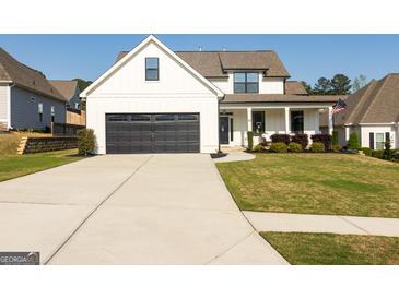Beautiful exterior view of a two story home with a large black garage door and landscaped front yard at 15 Dayton Way, Sharpsburg, GA 30277